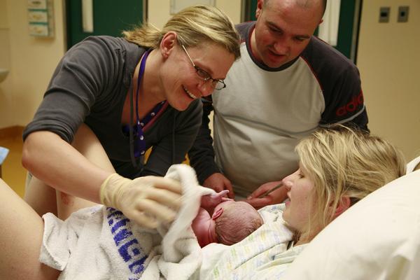 Midwife, newborn, mum and dad.